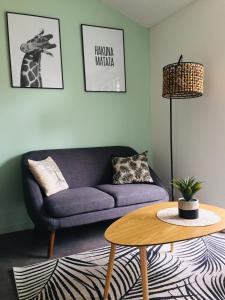 a living room with a purple couch and a table at Grand Studio avec terrasse proche de l'hypercentre de Lorient in Lorient