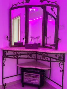 a pink bathroom with a vanity with a mirror at בחיק החרמון in Majdal Shams