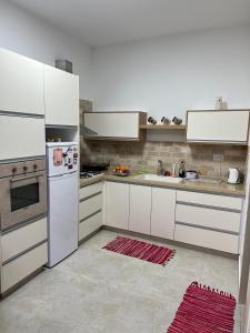 a kitchen with white cabinets and a white refrigerator at בחיק החרמון in Majdal Shams