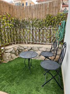 dos mesas y sillas en un patio trasero con una valla en בחיק החרמון, en Majdal Shams