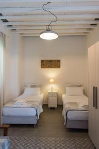a bedroom with two beds and a light fixture at Aerides Boutique Rooms in Vathi