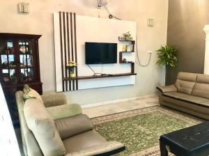 a living room with a couch and a television at The Nook, Kuala Terengganu in Kuala Terengganu