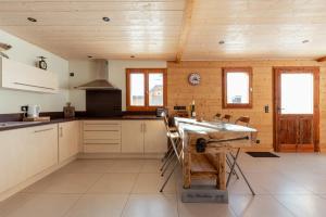 a kitchen with wooden walls and a wooden ceiling at Les Picaillons - Le Chalet in Les Villards-sur-Thônes