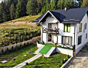 a white house with a solar roof on a hill at Bucovina Sky View in Gura Humorului