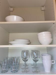 a shelf with plates and bowls and wine glasses at Studio apartment in Hafnarfjordur in Hafnarfjörður