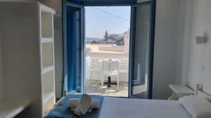 ein Schlafzimmer mit Bett und Blick auf eine Terrasse in der Unterkunft Augusta Studios & Apartments in Naoussa
