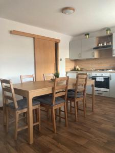 cocina con mesa de comedor de madera y sillas en Apartmán Staňkov, en Staňkov