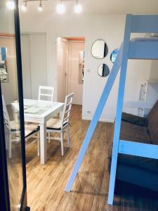 Un comedor con una mesa y una litera. en Agréable studio neuf avec vue + parking gratuit, en Luchon