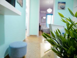 een woonkamer met een plant en een blauwe kruk bij Feels Like Home 2 in Athene