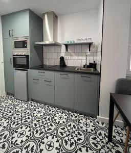 uma cozinha com armários cinzentos e piso em azulejo em MGG - Apartamento Muelle em Albacete