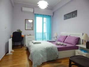 een slaapkamer met een paars bed en een bureau bij Feels Like Home 2 in Athene