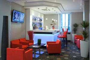 - une salle d'attente avec des chaises rouges et un bar dans l'établissement Allobroges Park Hôtel, à Annecy