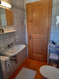 a bathroom with a white sink and a door at Haus Gmahblick Appartments in Alpbach +67 photos