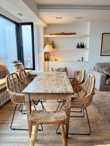 - un salon avec une table et des chaises en bois dans l'établissement Le Plein Ciel, à Knokke-Heist