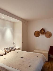- une chambre avec un grand lit et deux chapeaux sur le mur dans l'établissement Le Plein Ciel, à Knokke-Heist