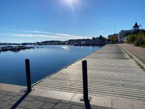 a wooden dock with boats in the water at New Apartment next to Kuopio Harbour with Sauna in Kuopio