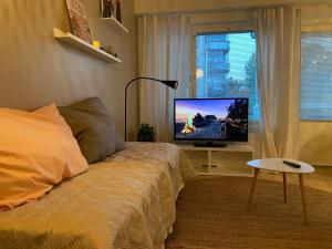 a bedroom with a bed and a flat screen tv at New Apartment next to Kuopio Harbour with Sauna in Kuopio