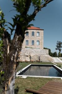a building with a swimming pool in front of a building at Casa Nova Rural in Nelas