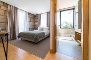 ein Schlafzimmer mit einem Bett und ein Bad mit einem Fenster in der Unterkunft Casa Nova Rural in Nelas + 94 Fotos