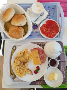 a tray of food with a plate of eggs cheese and tomatoes at Pokój Superior 1 - Willa Lawenda in Rytro