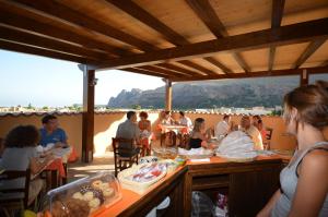 een groep mensen aan tafel op het strand bij Baia Santa Margherita B&B in Castelluzzo