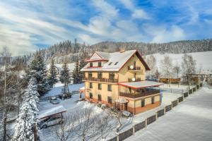 - une vue aérienne sur une maison dans la neige dans l'établissement Pensjonat OdNova, à Tylicz
