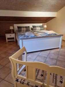 a large bed in a room with a chair at Ferienwohnung am Zeitenweg in Windeck