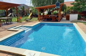 a swimming pool in a yard with a gazebo at Médea Apartman in Bük