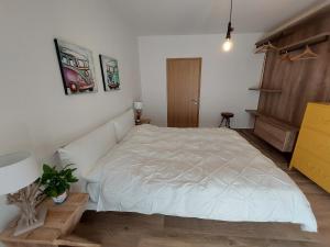 a bedroom with a white bed and a staircase at La bougainville - luxury apartment in Nago-Torbole +66 photos