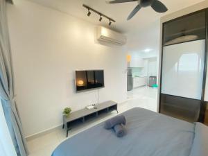 a bedroom with a bed and a flat screen tv at Teega Suites, Puteri Harbour, Iskandar Puteri in Nusajaya