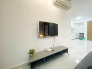 a living room with a television on a white wall at Teega Suites, Puteri Harbour, Iskandar Puteri in Nusajaya