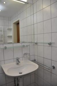 uma casa de banho branca com um lavatório e um espelho em Salve 9 em Leukerbad