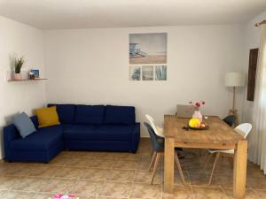 a living room with a blue couch and a table at Tu Casa in Puerto de Mazarrón