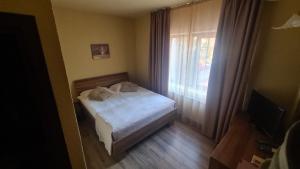 ブラショヴにあるHotel Gemaのベッドと窓のある小さな寝室