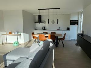 a living room with a couch and a dining room at Zeedroom 5 in Middelkerke