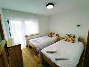 a small room with two beds and a window at Domek320 in Gronków