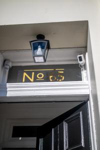 a sign above a door with a light above it at Casa Fresa - Orchar Suites in Dundee