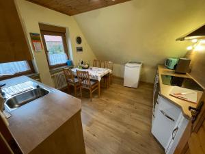 uma cozinha e sala de jantar com uma mesa e um lavatório em Ferienwohnung Beate Engelhardt em Kleinern
