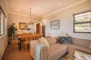 a living room with a couch and a table at Victoria Bay Holiday Cottage in George