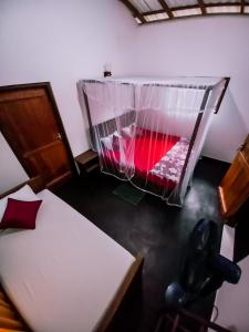 a room with a bed and a container with red liquid at Rainforest River Bay in Deniyaya