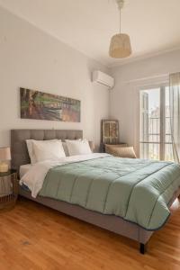 een slaapkamer met een groot bed en een groene deken bij Eχquisite apt in Acropolis-plaka/vaccinatedHost in Athene