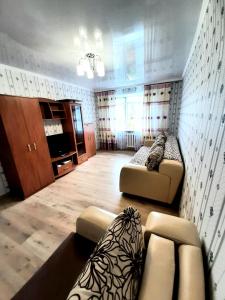 Sala de estar con 2 sofás y TV en Центр города. en Almaty
