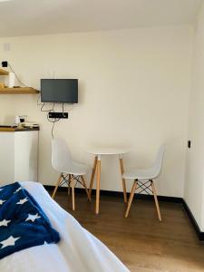 a bedroom with two chairs and a table and a tv at Marshall Apartment 202 in Gudauri +11 photos