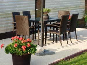 - une terrasse avec une table, des chaises et des fleurs dans l'établissement Penzion Verde, à Mikulov