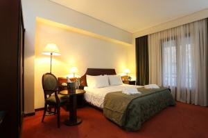 um quarto de hotel com uma cama e uma mesa com uma cadeira em Hotel Apollonia Delphi em Delfoi