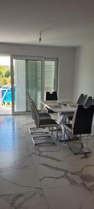 - une salle à manger avec une table et des chaises dans l'établissement Apartments San, à Lovište