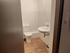 a white bathroom with a toilet and a sink at Apartament żeglarski Węgorzewo in Węgorzewo