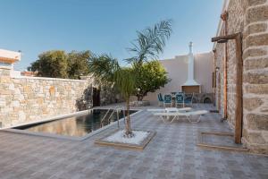 a courtyard with a palm tree next to a pool at Villa Anaflo in Haraki