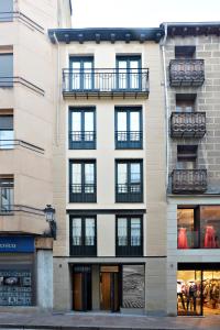 ein hohes Gebäude mit Fenstern und Balkonen darauf in der Unterkunft Apartamentos Abastos in Logroño