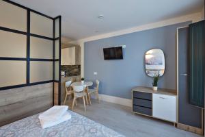 a bedroom with blue walls and a table with a mirror at Apartamentos Abastos in Logroño